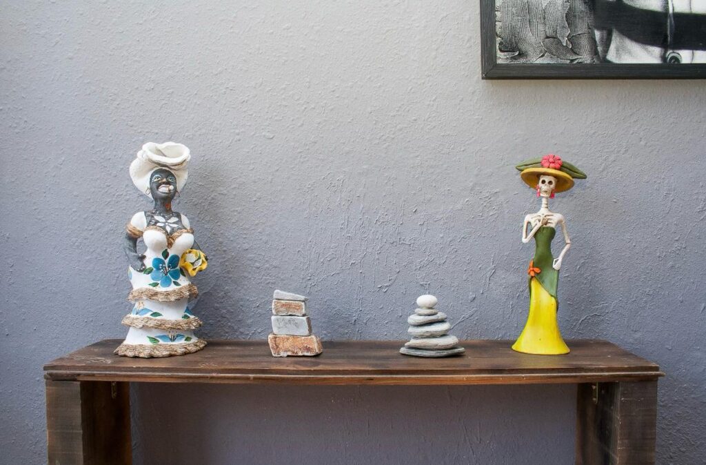 figuras decorativas cubanita y mexicana con dos montículos de piedras al lado. Figuras y concepto decorativo de interiorismo de Alexis Montero. 